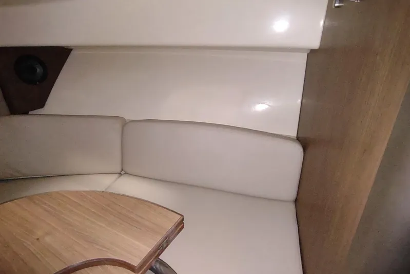  Yacht Photos Pics Interior of 2015 Boston Whaler 285 Conquest with cushioned seating and wooden table.