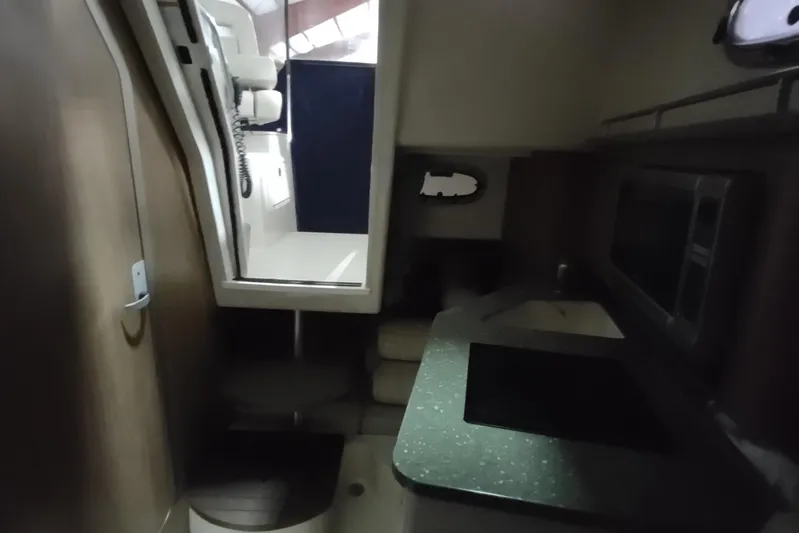  Yacht Photos Pics Interior of 2015 Boston Whaler 285 Conquest, featuring compact kitchen and seating area.