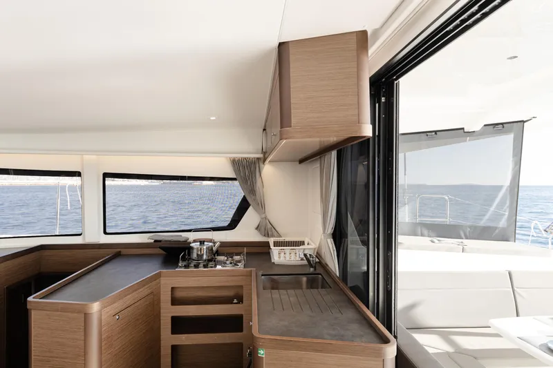 Yacht Photos Pics Interior of 2020 Lagoon 42 catamaran with modern kitchen and ocean view.