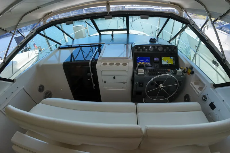 Sun Baked Yacht Photos Pics 1999 Tiara Yachts 3500 Express helm with navigation equipment and comfortable seating.
