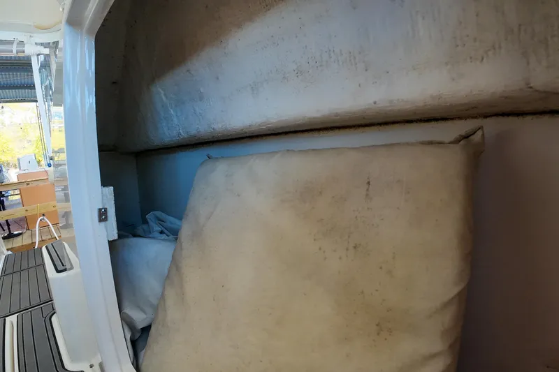 Sun Baked Yacht Photos Pics 1999 Tiara Yachts 3500 Express interior storage area with cushions and equipment.