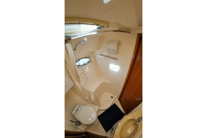 Sun Baked Yacht Photos Pics Bathroom interior of 1999 Tiara Yachts 3500 Express, featuring shower, toilet, and sink.
