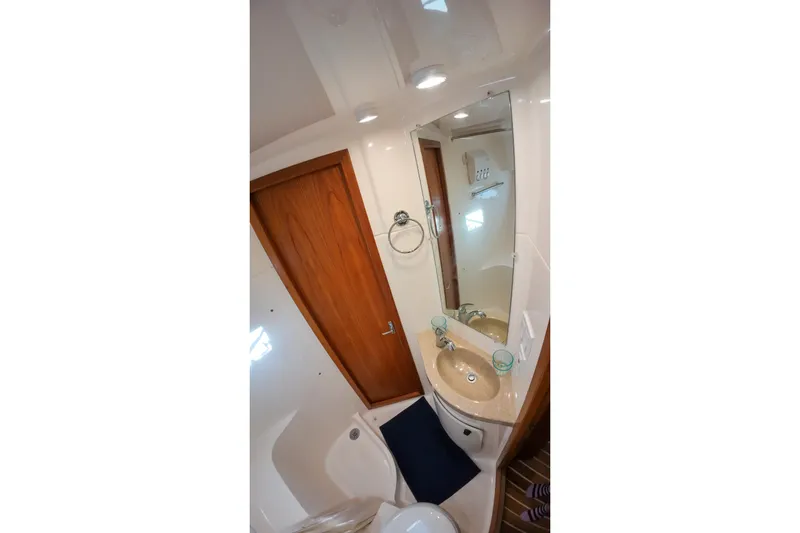 Sun Baked Yacht Photos Pics Bathroom interior of 1999 Tiara Yachts 3500 Express with sink and mirror.