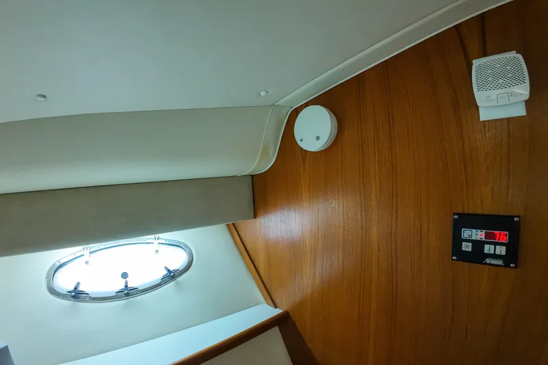 Sun Baked Yacht Photos Pics Interior of 1999 Tiara Yachts 3500 Express with wood paneling and porthole window.