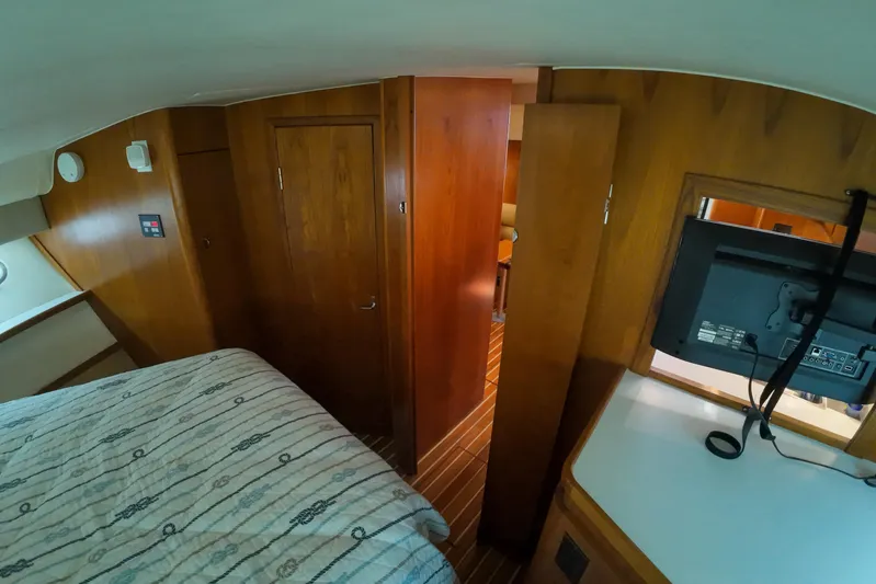 Sun Baked Yacht Photos Pics 1999 Tiara Yachts 3500 Express cabin interior with wood paneling and bed.