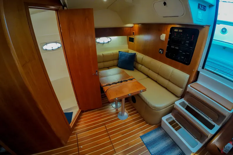 Sun Baked Yacht Photos Pics 1999 Tiara Yachts 3500 Express interior with wood accents and cozy seating area.