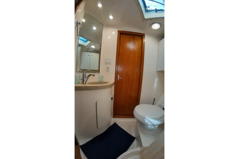 Sun Baked Yacht Photos Pics Bathroom interior of 1999 Tiara Yachts 3500 Express with sink, mirror, and toilet.