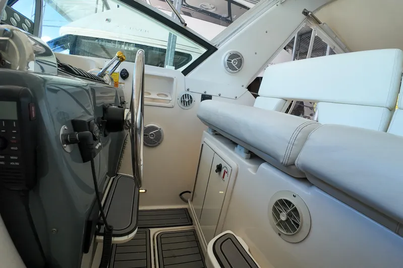 Sun Baked Yacht Photos Pics 1999 Tiara Yachts 3500 Express interior with steering wheel and seating area.