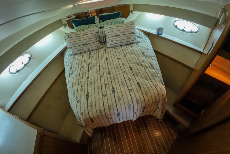 Sun Baked Yacht Photos Pics 1999 Tiara Yachts 3500 Express cabin with cozy bed and nautical decor.