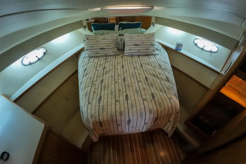 Sun Baked Yacht Photos Pics Cozy cabin interior of 1999 Tiara Yachts 3500 Express with striped bedding.