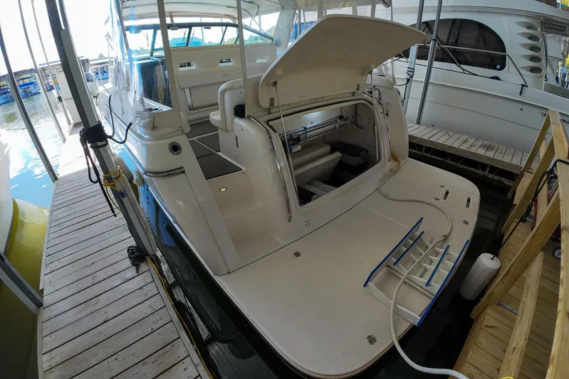 Sun Baked Yacht Photos Pics 1999 Tiara Yachts 3500 Express docked, showcasing open storage compartment and spacious deck.