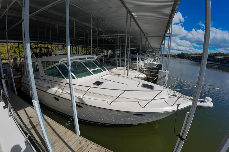 Sun Baked Yacht Photos Pics 1999 Tiara Yachts 3500 Express docked under a covered marina on a sunny day.
