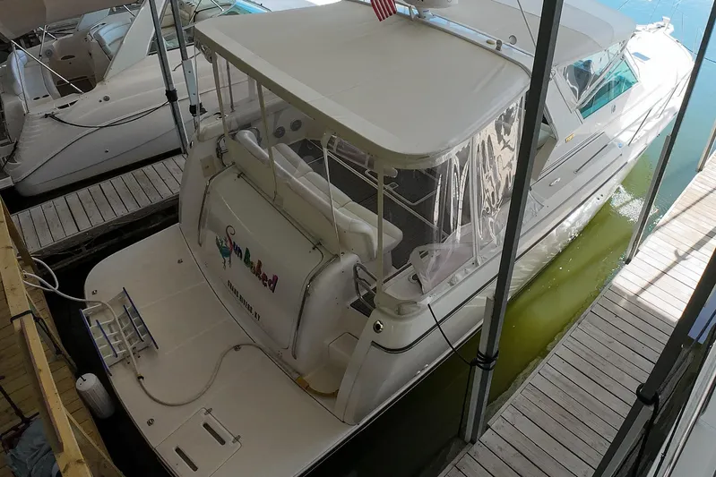 Sun Baked Yacht Photos Pics 1999 Tiara Yachts 3500 Express docked, featuring a spacious deck and covered seating area.