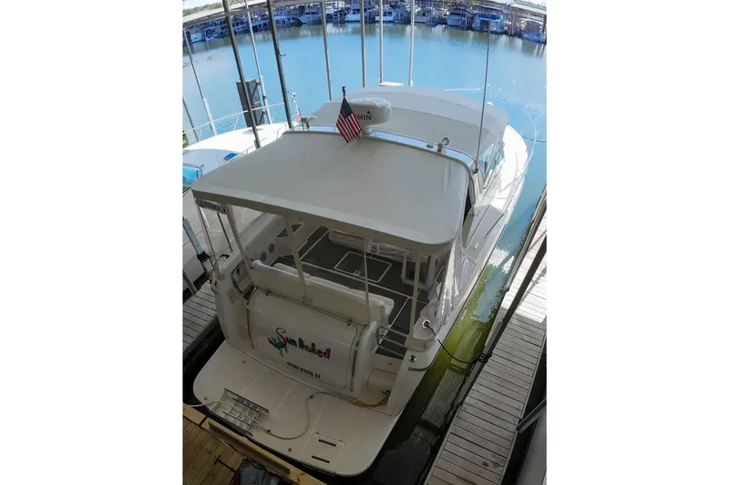 Sun Baked Yacht Photos Pics 1999 Tiara Yachts 3500 Express docked, rear view with American flag.