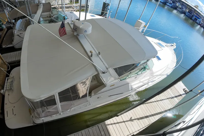 Sun Baked Yacht Photos Pics 1999 Tiara Yachts 3500 Express docked, featuring a spacious deck and canopy.