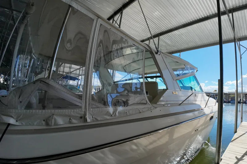 Sun Baked Yacht Photos Pics 1999 Tiara Yachts 3500 Express docked under a covered marina.