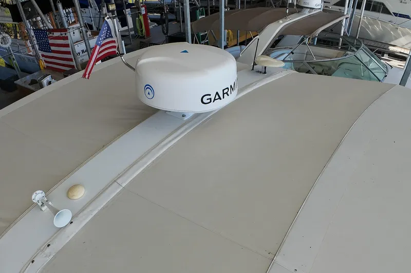 Sun Baked Yacht Photos Pics 1999 Tiara Yachts 3500 Express with Garmin radar, docked with American flags displayed.