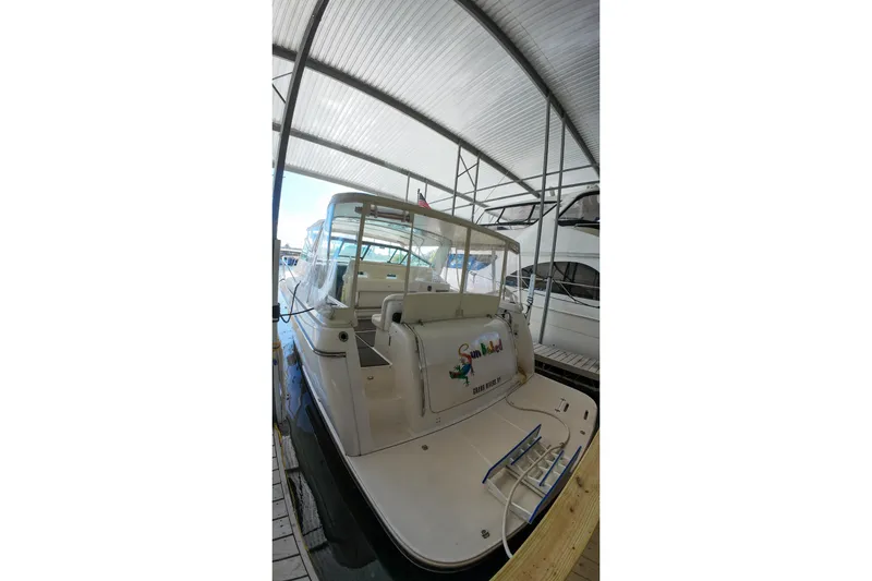 Sun Baked Yacht Photos Pics 1999 Tiara Yachts 3500 Express docked under a covered marina.