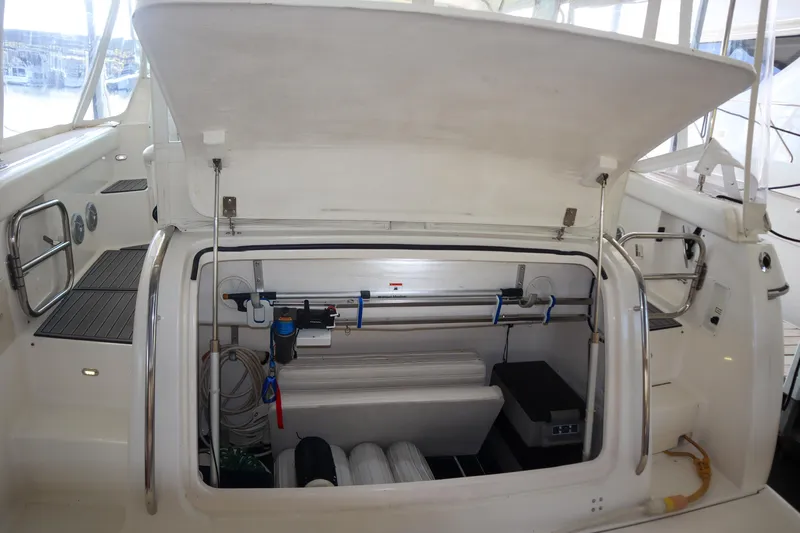 Sun Baked Yacht Photos Pics 1999 Tiara Yachts 3500 Express storage compartment with open hatch, showcasing interior equipment.