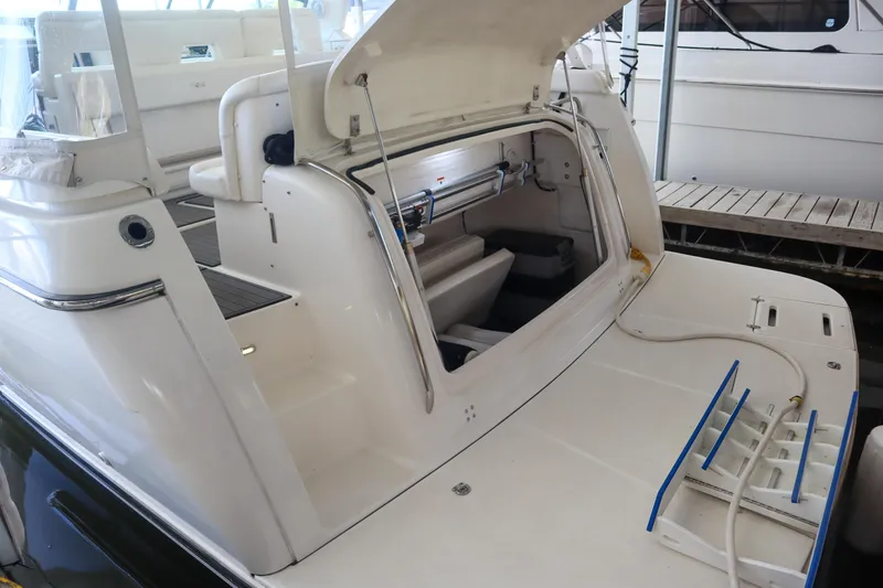 Sun Baked Yacht Photos Pics 1999 Tiara Yachts 3500 Express with open engine compartment, docked at marina.