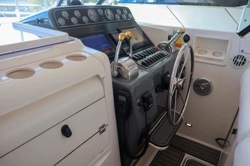 Sun Baked Yacht Photos Pics 1999 Tiara Yachts 3500 Express helm with steering wheel and control panel.
