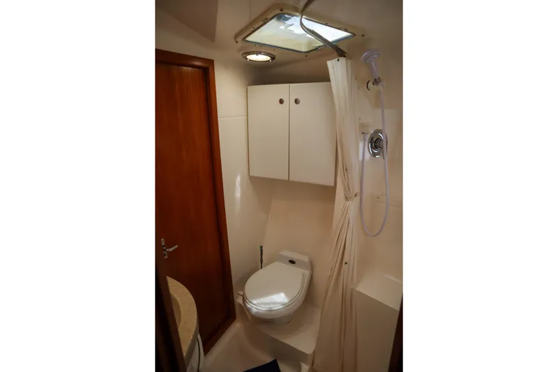 Sun Baked Yacht Photos Pics 1999 Tiara Yachts 3500 Express bathroom with shower, toilet, and storage cabinets.