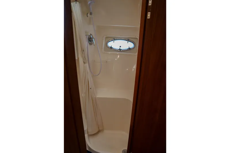Sun Baked Yacht Photos Pics Shower area in 1999 Tiara Yachts 3500 Express, featuring a compact design and porthole window.