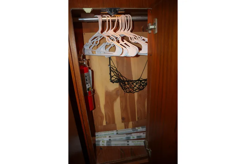 Sun Baked Yacht Photos Pics 1999 Tiara Yachts 3500 Express closet with hangers, fire extinguisher, and storage net.