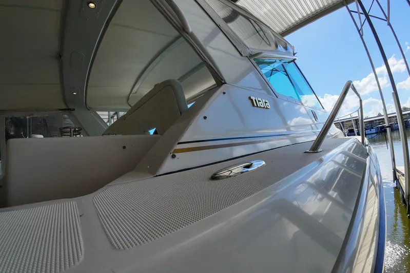 Sun Baked Yacht Photos Pics 1999 Tiara Yachts 3500 Express docked under a canopy, showcasing sleek design and craftsmanship.