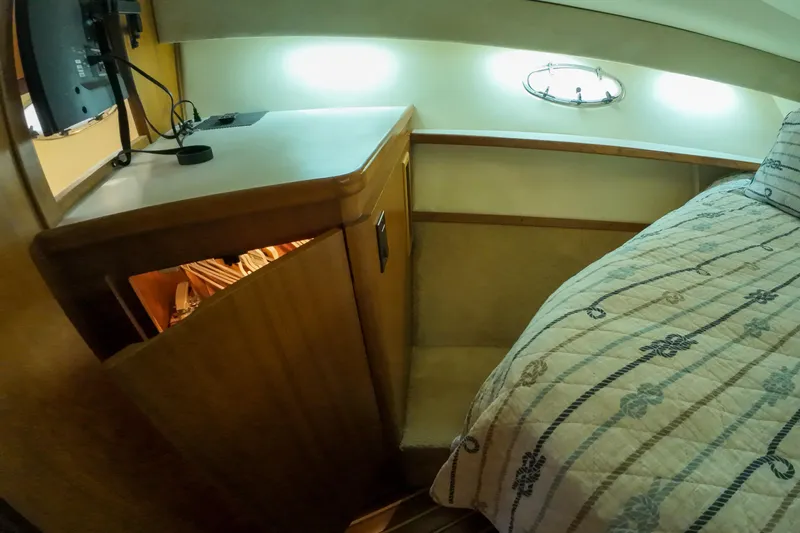 Sun Baked Yacht Photos Pics 1999 Tiara Yachts 3500 Express cabin interior with bed and storage cabinet.