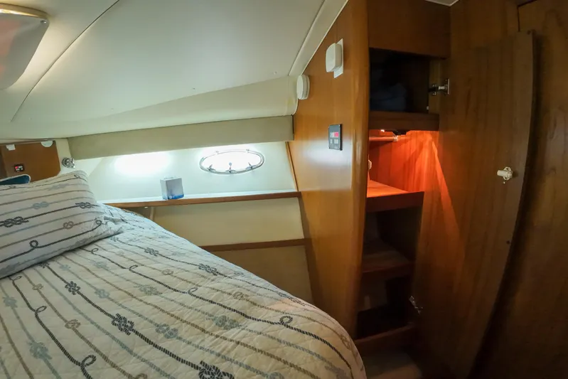 Sun Baked Yacht Photos Pics 1999 Tiara Yachts 3500 Express cabin interior with bed and wooden storage.