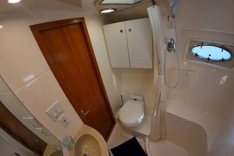 Sun Baked Yacht Photos Pics 1999 Tiara Yachts 3500 Express bathroom with shower, sink, and wooden door.
