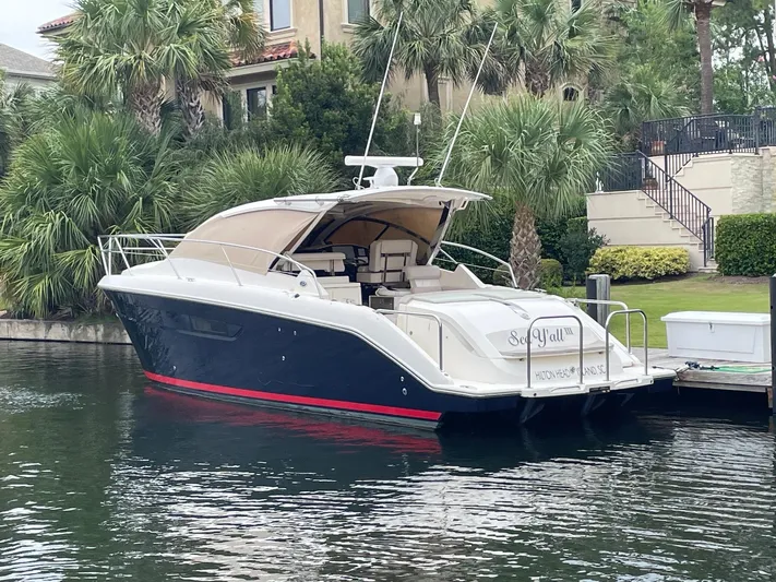 Sea Y'all III Yacht Photos Pics 2014 Pursuit SC 365i Sport Coupe docked by lush greenery.