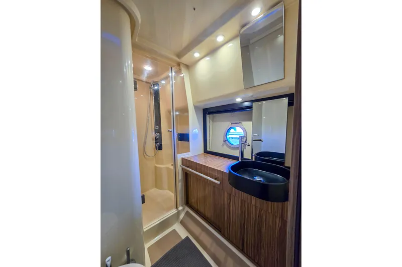 Rumble Bee Yacht Photos Pics Luxurious bathroom in 2015 Azimut Magellano 43 yacht with modern fixtures and porthole window.