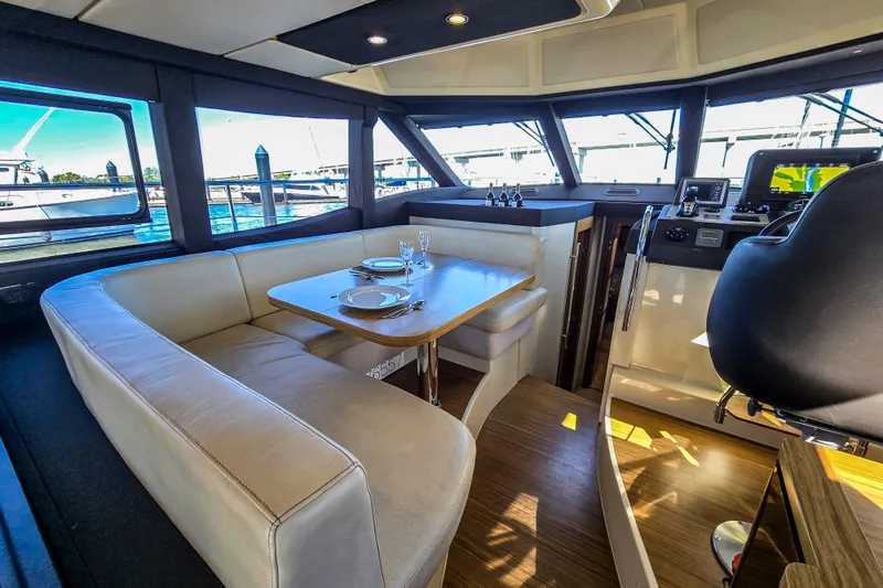 Rumble Bee Yacht Photos Pics Interior of 2015 Azimut Magellano 43 yacht with dining area and helm station.