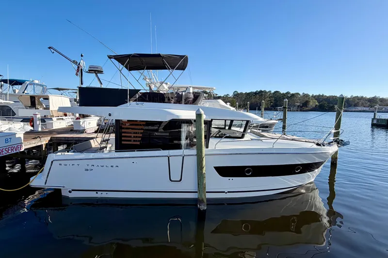  Yacht Photos Pics 2026 Beneteau Swift Trawler 37 Fly moored at a marina, side view.