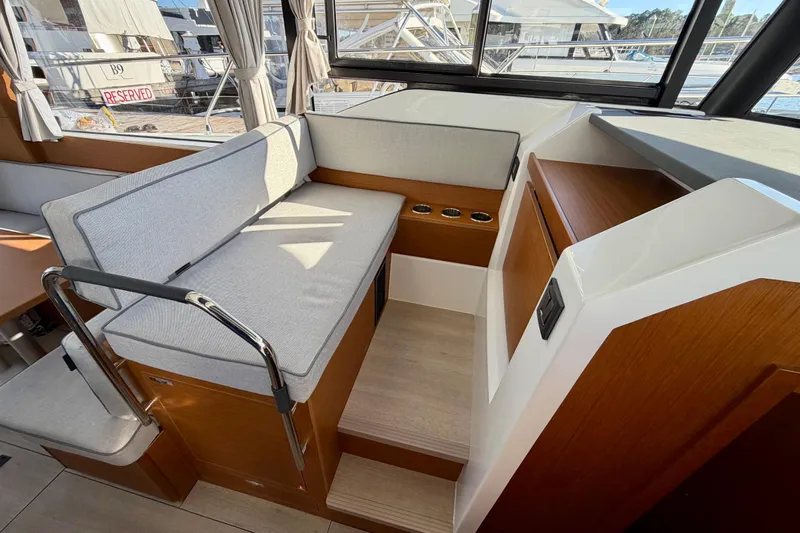  Yacht Photos Pics Interior of 2026 Beneteau Swift Trawler 37 Fly with cushioned seating and wooden accents.