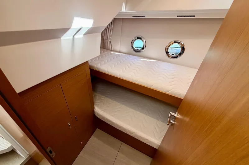  Yacht Photos Pics 2026 Beneteau Swift Trawler 37 Fly cabin with bunk beds and porthole windows.