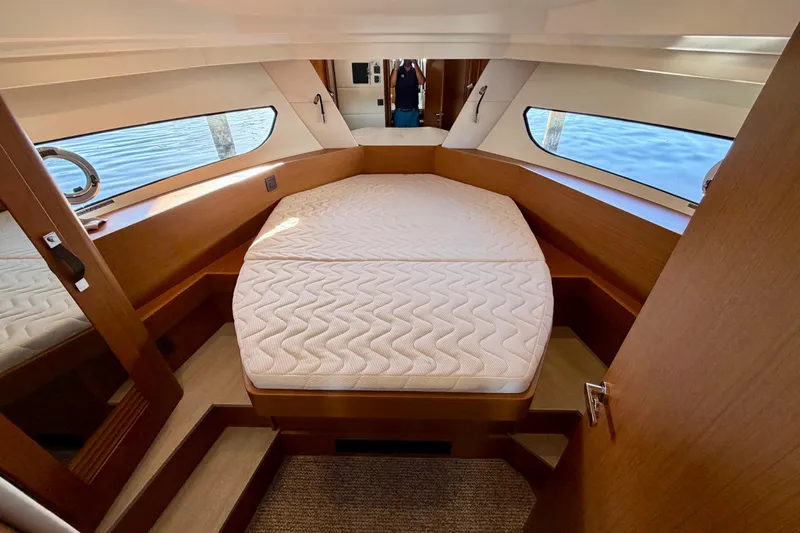  Yacht Photos Pics Interior cabin of 2026 Beneteau Swift Trawler 37 Fly with cozy bed and wooden finish.