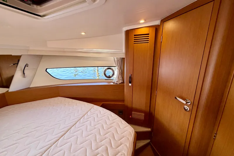  Yacht Photos Pics 2026 Beneteau Swift Trawler 37 Fly cabin interior with wooden finish and cozy bed.