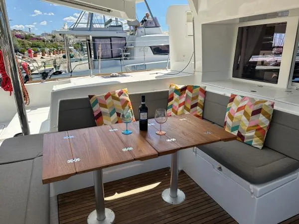 Angels Share Yacht Photos Pics Cozy outdoor seating on 2015 Lagoon 450 F yacht with colorful cushions and wine setup.