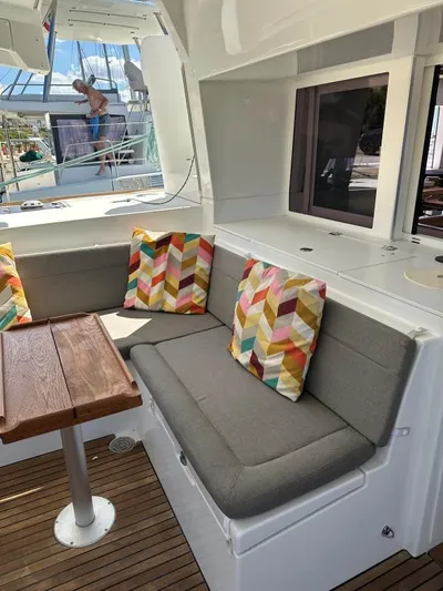 Angels Share Yacht Photos Pics Cozy seating area on 2015 Lagoon 450 F yacht with colorful cushions and wooden table.