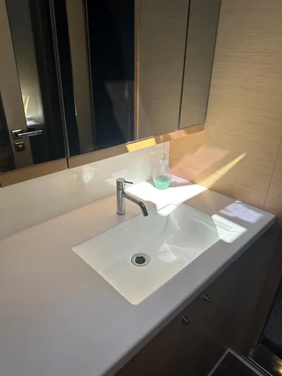 Angels Share Yacht Photos Pics Modern bathroom sink in 2015 Lagoon 450 F yacht, featuring sleek design and mirrored cabinets.