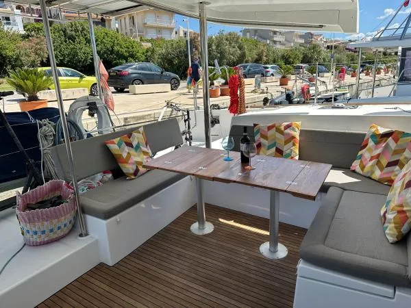 Angels Share Yacht Photos Pics Outdoor seating area on 2015 Lagoon 450 F yacht with colorful cushions and table.