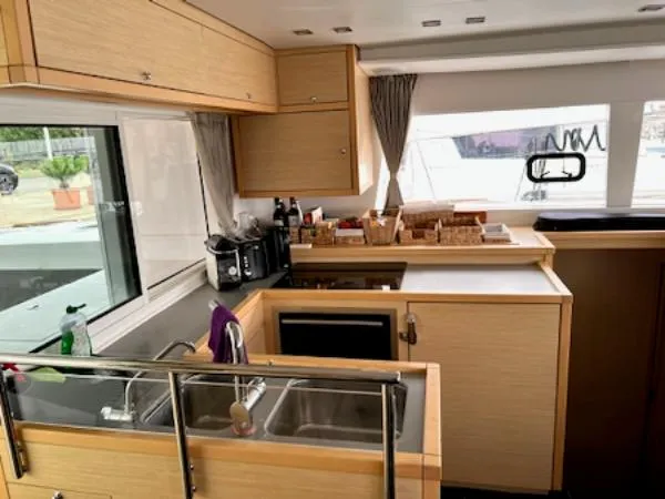 Angels Share Yacht Photos Pics Modern kitchen interior of 2015 Lagoon 450 F yacht with wooden cabinetry and appliances.