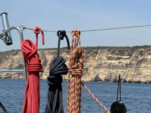 Angels Share Yacht Photos Pics Colorful ropes on a Lagoon 450 F sailboat with rocky coastline backdrop.