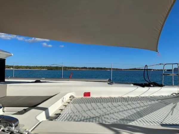 Angels Share Yacht Photos Pics Lagoon 450 F catamaran deck with sunshade, overlooking serene blue waters.