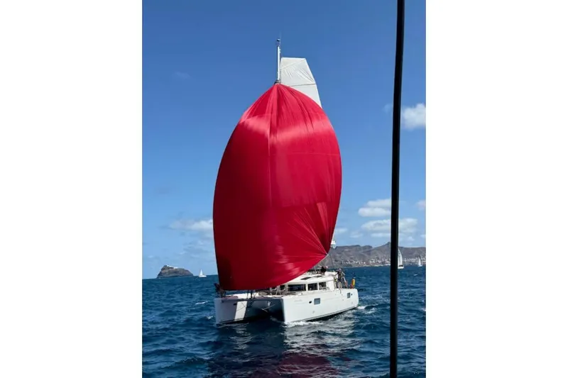 Angels Share Yacht Photos Pics Lagoon 450 F catamaran sailing with a vibrant red spinnaker, 2015 model.