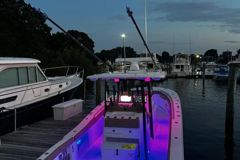  Yacht Photos Pics 2024 Caymas 341 CC boat docked at marina during twilight with vibrant interior lighting.