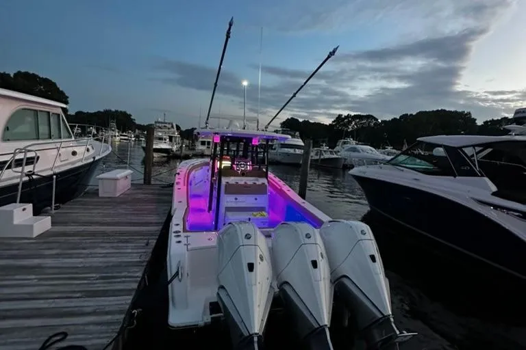 Yacht Photos Pics 2024 Caymas 341 CC boat docked at marina, illuminated with purple lights at dusk.